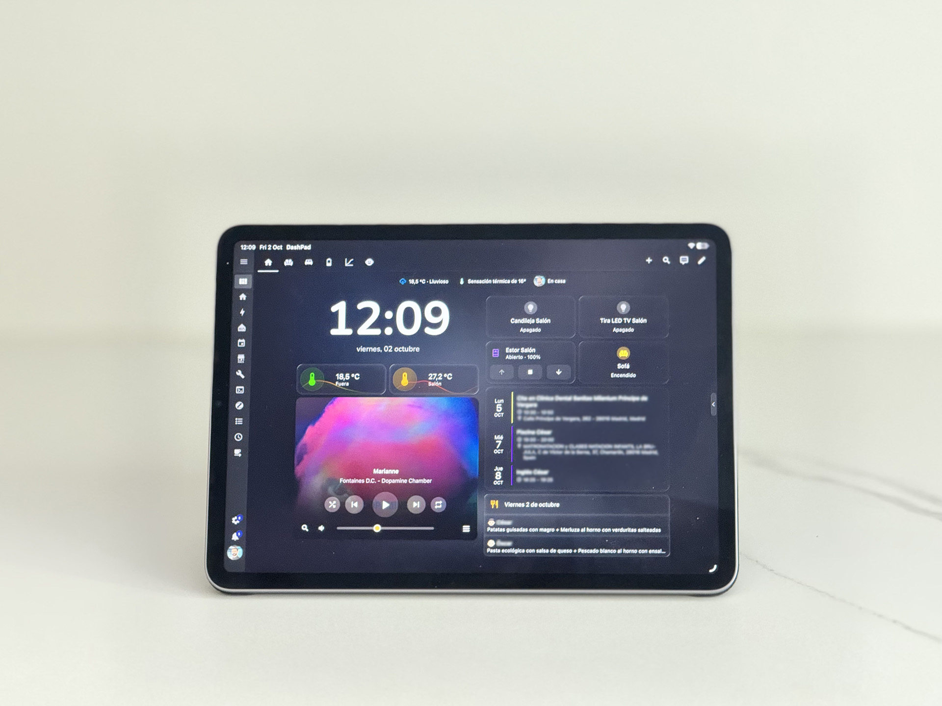 DashPad running on an iPad on a stand, showing a Home Assistant dashboard with the time, temperatures, a music player, lights, blinds and a calendar